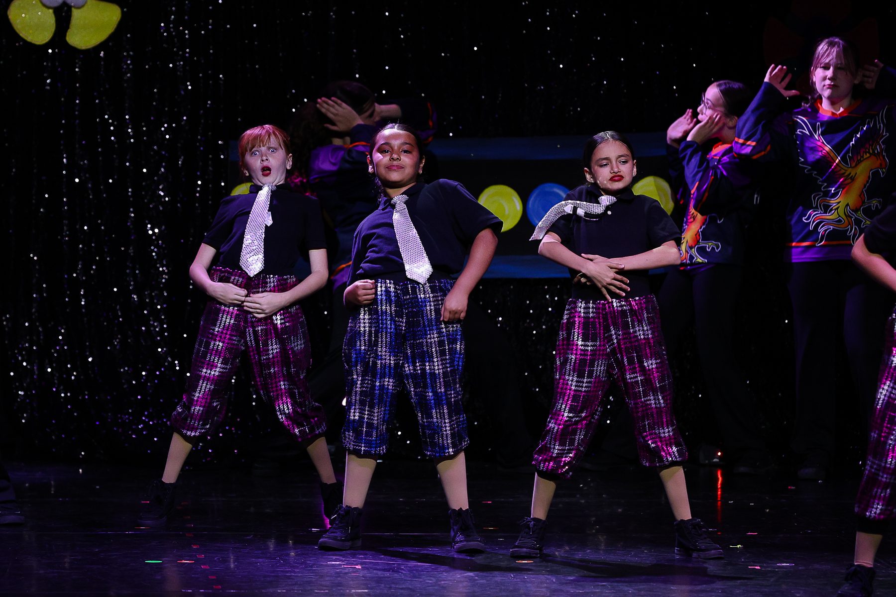 Hip hop dancers in plaid pants and sequin ties at an Ignite Your Flare recital