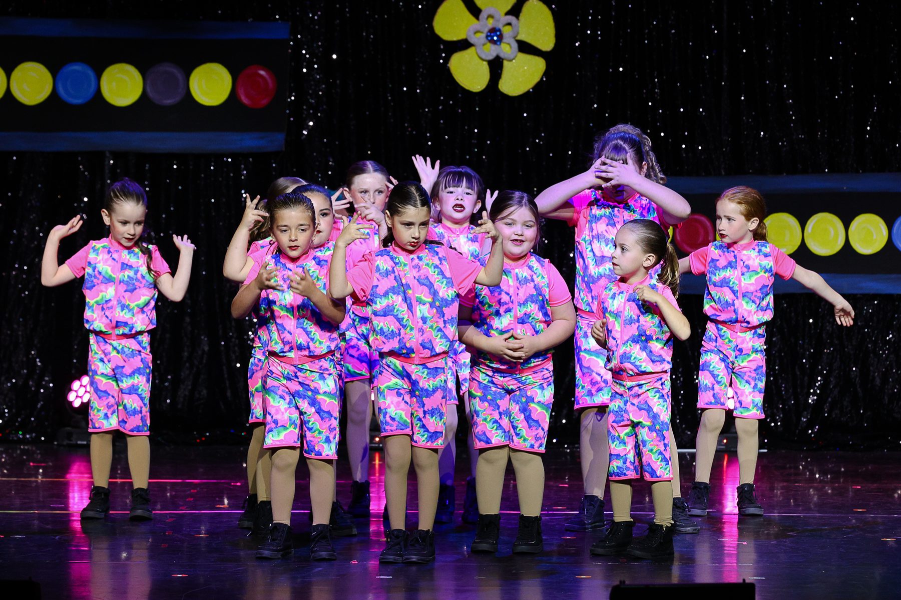 Young hip hop dancers in bright printed costumes at an Ignite Your Flare recital