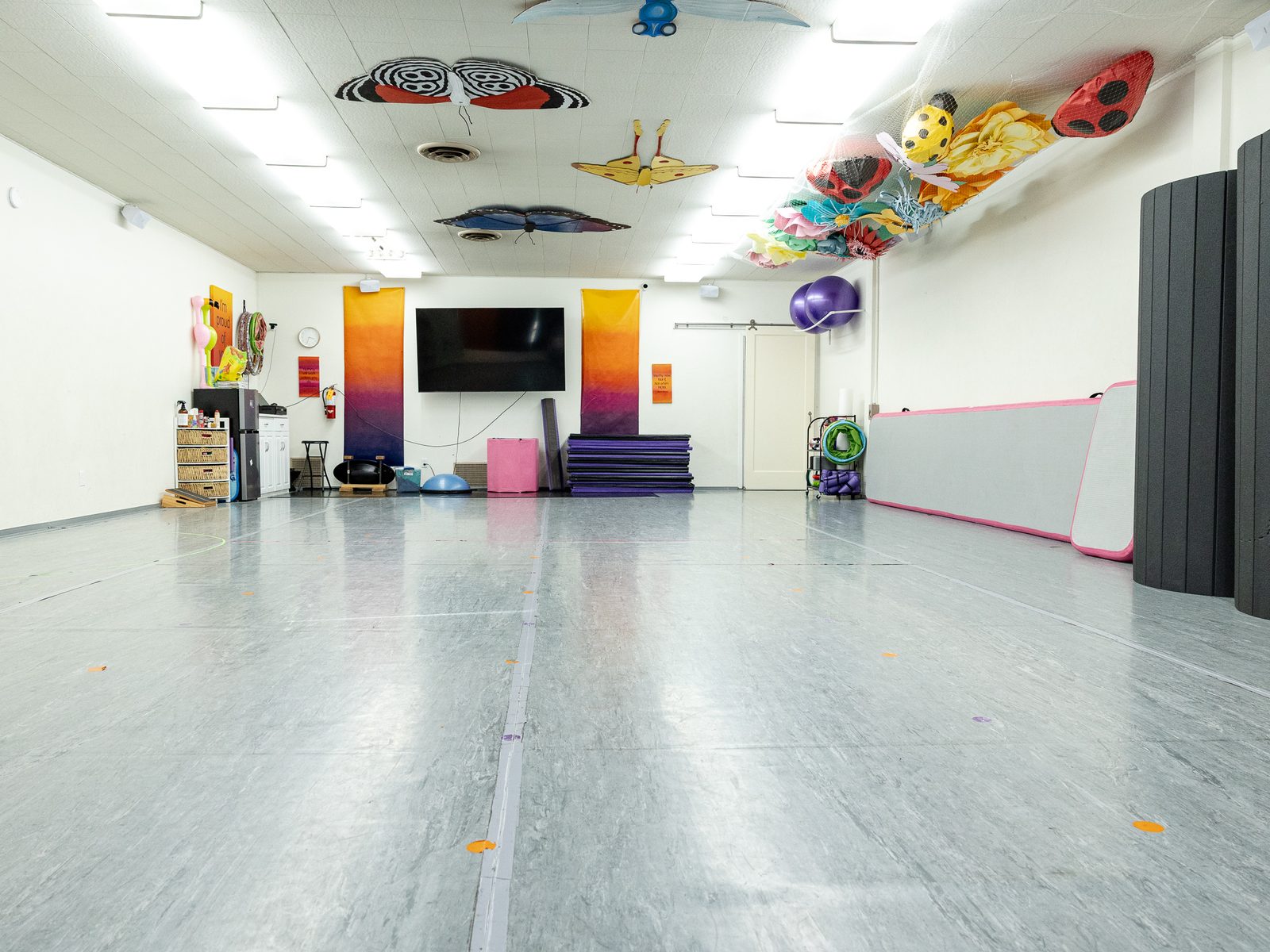 Studio 1, the acro room, with tumble track, mats and paper butterflies on the ceiling